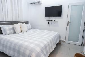 多拉多Aquaville Dorado Moderna Villa 4的卧室配有一张床铺,墙上配有电视