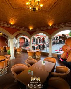 阿拉莫斯Hotel Real de los Alamos的餐厅设有泰迪熊和桌椅