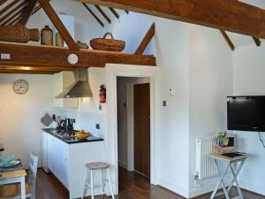 West HoathleyHoney Meadow Cottage的厨房设有白色的墙壁和木梁。