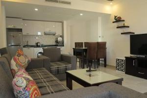 加利布港Marina city port ghalib chalet的带沙发和桌子的客厅以及厨房。