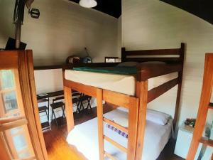 格拉玛多Paraíso dos Ciclistas的一间卧室配有一张双层床和一张桌子及椅子