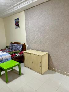达喀尔GHEST HOUSE BASS的客房设有床、绿桌和墙壁