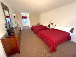 北怀尔德伍德Cardinal Motel的酒店客房设有两张床和一台平面电视。