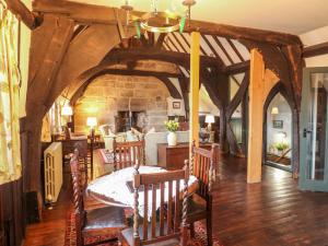 塔姆沃思Porter's Lodge的一间设有桌椅和石墙的用餐室