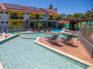 博尼图马鲁阿酒店的一个带两把椅子的游泳池以及一座房子