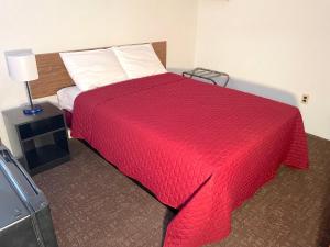 北怀尔德伍德Cardinal Motel的一间卧室配有一张带红色毯子的床