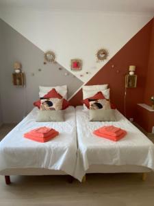 ReillanneChambre d'hôtes Zephyr Libeccio Le Moulin de Prédelles的一间卧室配有两张红色床单