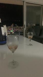 佛罗里达布兰卡Habitaciones vista azul campestre-diagonal a la Foscal的两杯酒杯坐在桌子上,窗户