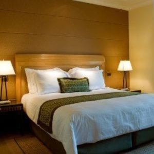 基塔莱Cloud9 Suites的一张大床,位于酒店带两盏灯的房间
