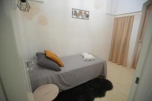 切列梅萨皮卡A&K HOME的一间小卧室,配有带枕头和桌子的床