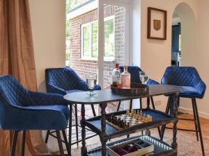 坎特伯雷Bay House的一间设有椅子和桌子的房间,配有酒瓶和酒杯