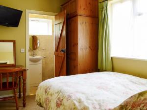 圣伦纳兹奥克迪恩度假屋的一间卧室配有床、水槽和窗户