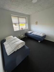 海宁Nyt hus的一间卧室设有两张床,其中设有窗户。