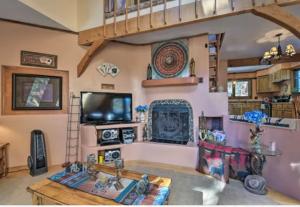 天使之火Raven’s Nest Cabin with Glowing Bocce Ball Court的客厅设有壁炉和电视。