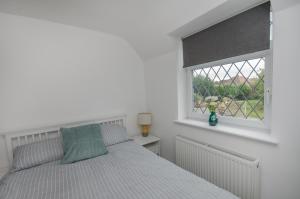 布里斯托Hideaway Cottage的白色的卧室设有床和窗户