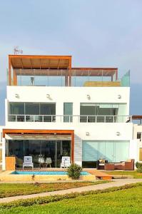 帕拉卡斯Solymar Beach House - Paracas的一座大型白色房子,有很多窗户