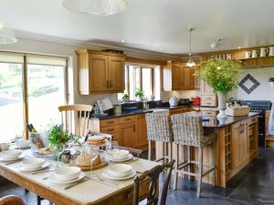 LlanwrdaMaes Y Bryn Farmhouse的厨房配有木桌和餐具