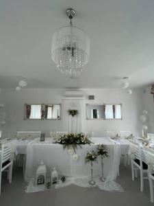 RadavaPenzión Fonte的白色的客房配有白色的桌子和吊灯