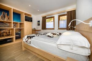 普雷达佐B&B B&Beautyfol Dolomites adults only的一间卧室配有一张大床,上面有灯