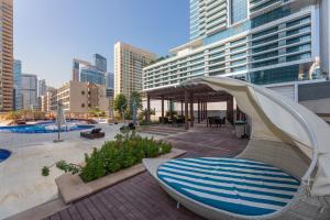 迪拜Dubai Marina - 5 bedroom, resort feel, great Amenities的一个带游泳池、椅子和遮阳伞的度假村