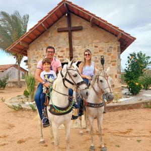 Serra de São BentoChalé bons ventos的骑着马在教堂前骑行的家庭