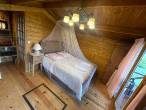 Marais-Vernier7eme ciel - Tiny House avec Grande Piscine intérieure chauffée toute l'année的一间卧室配有一张带蚊帐的床