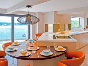 班戈Tan Y Fford的一个带桌子和橙色椅子的厨房和一个带小岛的厨房