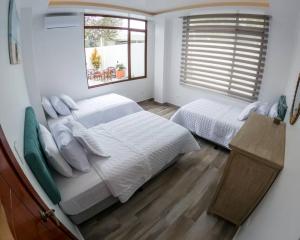 马查利亚Hermosa Casa de Playa Machalilla的一间卧室设有两张床和窗户。
