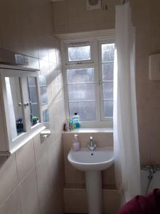 伦敦Double room for One Person in 3 beds flat的一间带水槽和窗户的浴室