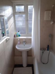 伦敦Double room for One Person in 3 beds flat的一间带水槽、窗户和浴缸的浴室