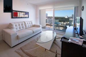 埃斯特角城Apartamento Punta del Este,Wind Tower 2 dormitorios的客厅配有白色沙发和玻璃桌