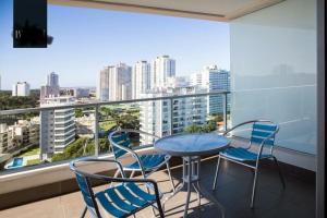 埃斯特角城Apartamento Punta del Este,Wind Tower 2 dormitorios的市景阳台配有桌椅