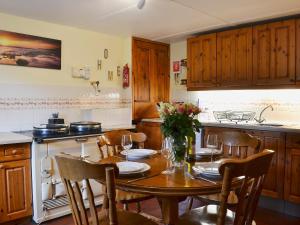 卡布里奇West End Cottage的一间带木桌和椅子的厨房以及一间用餐室