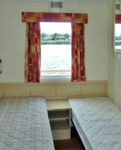 JabelHouse Boat Jabel的客房设有两张床和窗户。
