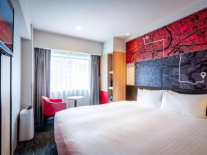 大阪大阪梅田宜必思酒店的酒店客房,设有床铺和红色的墙壁