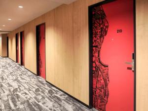 大阪大阪梅田宜必思酒店的走廊上一排有红色墙壁的门