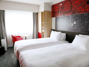 大阪大阪梅田宜必思酒店的酒店客房设有两张床和窗户。