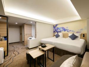 那霸冲绳那霸诺富特酒店的酒店客房,设有两张床和一张沙发