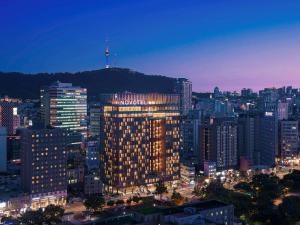首尔诺富特大使首尔东大门酒店的城市的一座有灯光的建筑