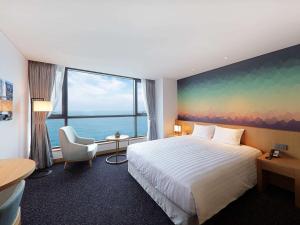 蔚山Mercure Ambassador Ulsan的酒店客房设有一张床和一个大窗户