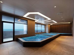 蔚山Mercure Ambassador Ulsan的一个带窗户的房间,有一个大型游泳池