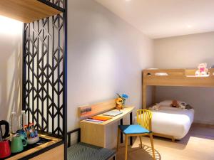 曼谷ibis Styles Bangkok Ratchada的一间小卧室,配有双层床和书桌