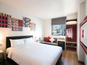 曼谷宜必思曼谷素坤逸 24 号酒店的一间带白色大床的卧室和一间浴室