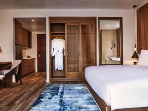 富国Mövenpick Villas & Residences Phu Quoc的一间带白色床的卧室和一间浴室