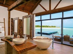 马纳杜岛Mӧvenpick Resort Kuredhivaru Maldives的一间带两个盥洗盆的浴室和一个大窗户