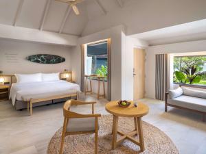 梅尔皮姆Mercure Rayong Lomtalay Villas & Resort的一间卧室配有一张床、一张桌子和一张沙发