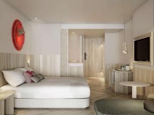 梅尔皮姆Mercure Rayong Lomtalay Villas & Resort的卧室配有一张白色大床和电视。