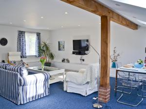 Witnesham芬斯农车度假屋的客厅配有白色家具和电视