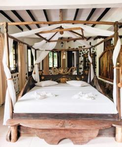 武吉拉旺Jungle Inn Bukit lawang的卧室配有带白色床单的天蓬床