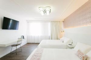 克雷塔罗Casa Oxa Hotel的一间酒店客房,设有两张床和电视